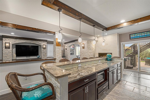 2349 Hickory Pl, Erie, CO 80516 - kitchen with stainless steel microwave, open floor plan, stone counters, and beam ceiling