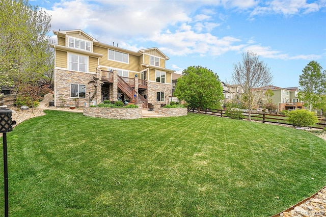 2349 Hickory Pl, Erie, CO 80516 - back of house featuring fence, stone siding, a wooden deck, stairway, and a yard