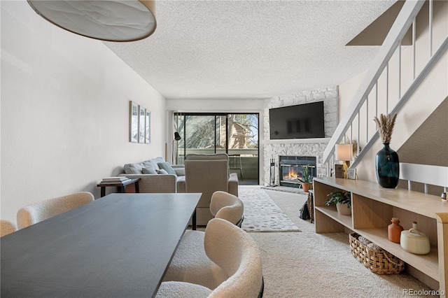 8773 W Cornell Ave Unit 10, Lakewood, CO 80227 - dining space featuring a stone fireplace, a textured ceiling, stairway, and carpet floors