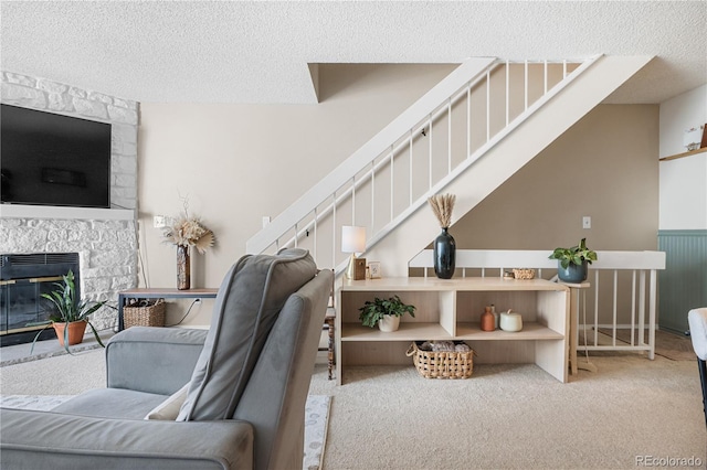 8773 W Cornell Ave Unit 10, Lakewood, CO 80227 - living room featuring stairway, a textured ceiling, carpet, and a stone fireplace
