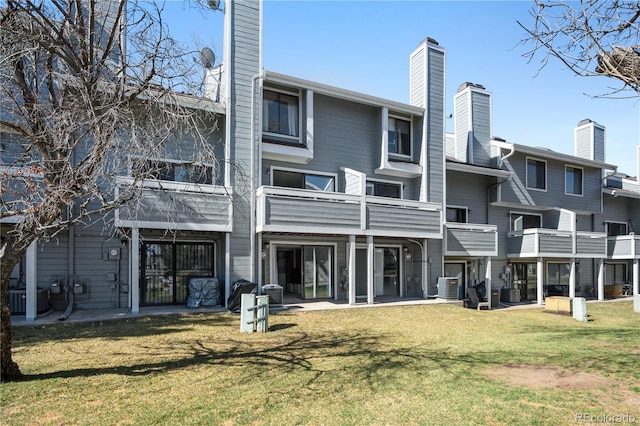 8773 W Cornell Ave Unit 10, Lakewood, CO 80227 - back of property featuring central AC unit, a lawn, and a chimney