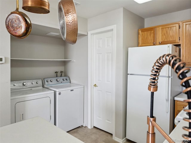 8621 E Dry Creek Rd Unit 325, Englewood, CO 80112 - laundry room with separate washer and dryer, light tile patterned flooring, and cabinet space