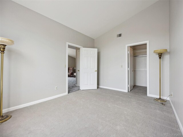 8621 E Dry Creek Rd Unit 325, Englewood, CO 80112 - unfurnished bedroom with carpet, baseboards, a walk in closet, and high vaulted ceiling