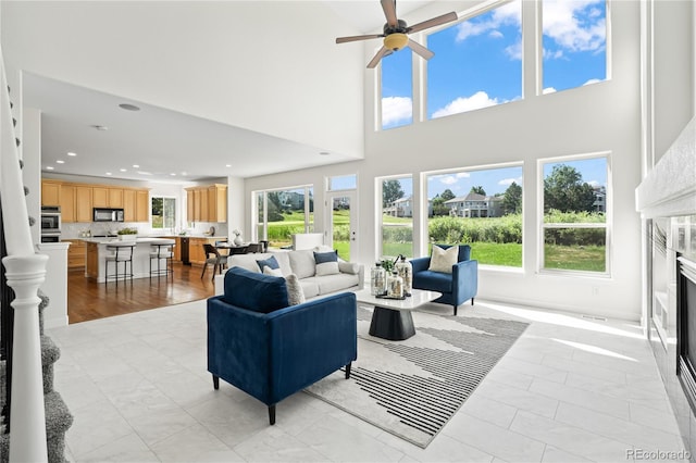 1511 Peninsula Cir, Castle Rock, CO 80104 - living area with ceiling fan, a premium fireplace, a towering ceiling, and recessed lighting