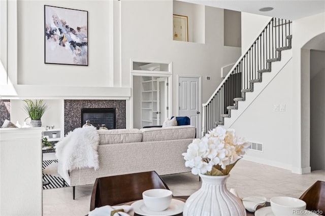 1511 Peninsula Cir, Castle Rock, CO 80104 - living room featuring a towering ceiling, stairs, a high end fireplace, and arched walkways