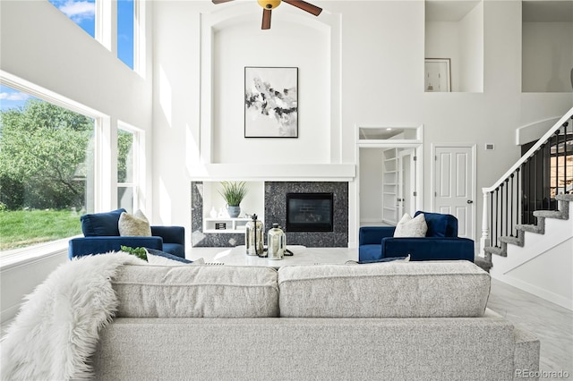 1511 Peninsula Cir, Castle Rock, CO 80104 - living room with a high ceiling, marble finish flooring, stairs, a ceiling fan, and a premium fireplace