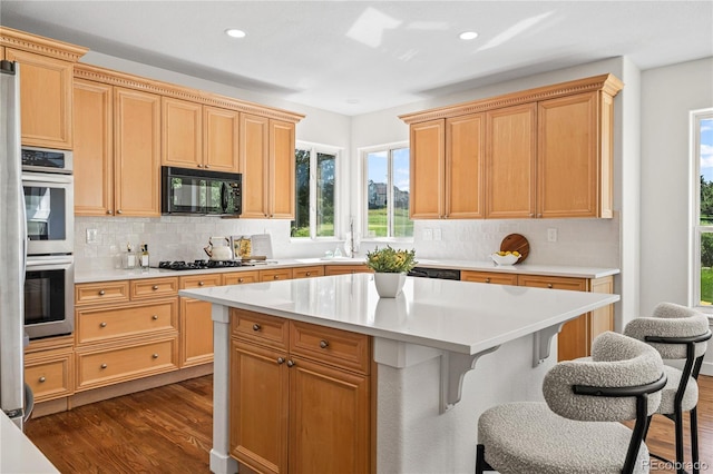 1511 Peninsula Cir, Castle Rock, CO 80104 - kitchen with black microwave, stainless steel double oven, dark wood-style flooring, tasteful backsplash, and light countertops