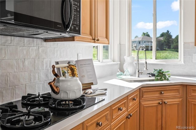1511 Peninsula Cir, Castle Rock, CO 80104 - kitchen featuring black appliances, tasteful backsplash, light countertops, and brown cabinetry