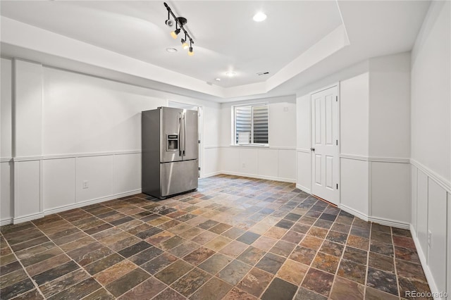 1511 Peninsula Cir, Castle Rock, CO 80104 - unfurnished room featuring stone tile flooring, a decorative wall, and a raised ceiling