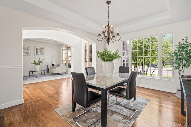 1511 Peninsula Cir, Castle Rock, CO 80104 - dining room with a tray ceiling, arched walkways, a chandelier, plenty of natural light, and ornamental molding