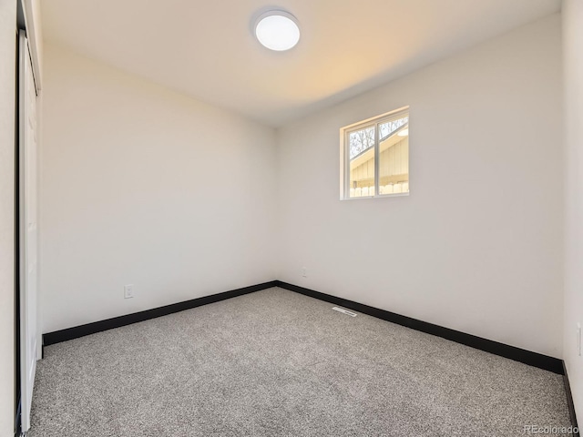 carpeted spare room with baseboards