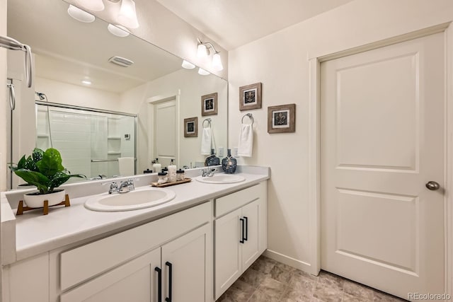 bathroom with vanity and a shower with shower door