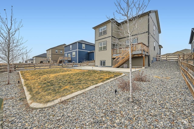 rear view of house with a wooden deck and a lawn