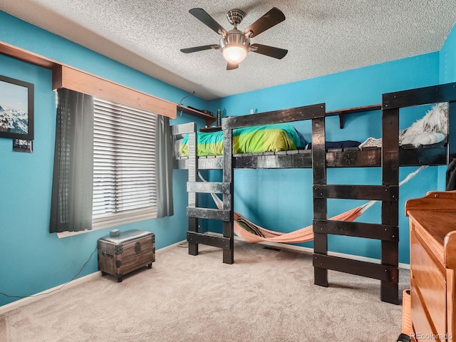 carpeted bedroom with ceiling fan and a textured ceiling