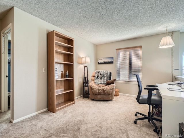 carpeted office space featuring a textured ceiling