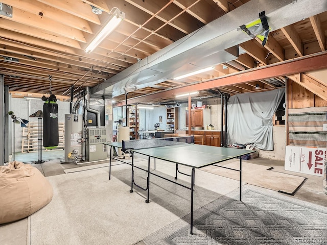 game room featuring heating unit and water heater