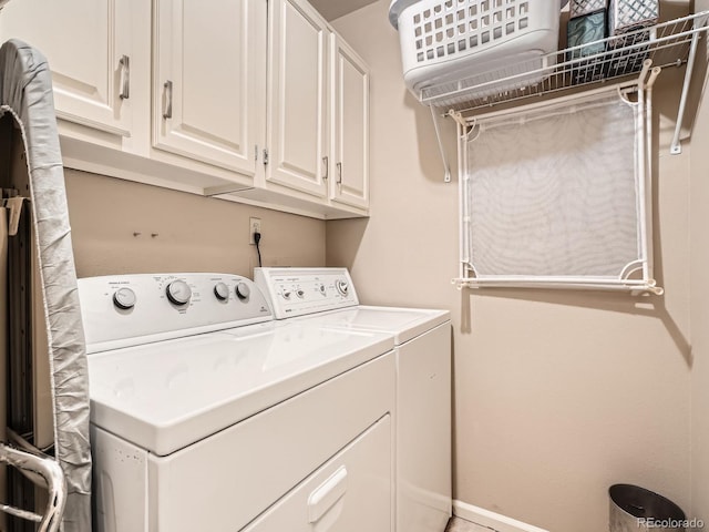 laundry area with cabinets and washing machine and clothes dryer