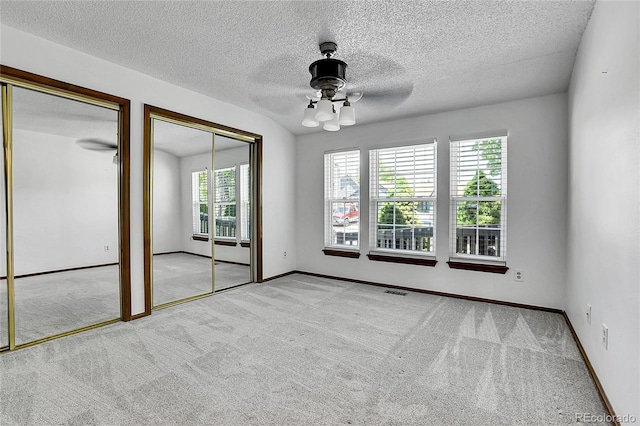 13270 W 65th Ave, Arvada, CO 80004 - unfurnished bedroom featuring multiple closets, carpet, ceiling fan, a textured ceiling, and baseboards