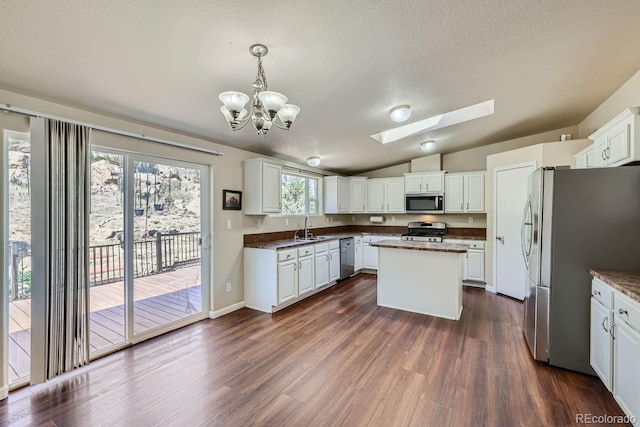 kitchen featuring pendant lighting, white cabinetry, sink, a center island, and stainless steel appliances