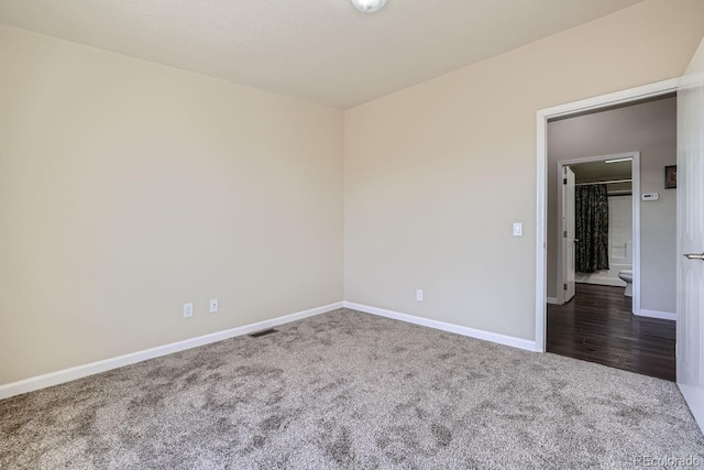 spare room featuring dark carpet