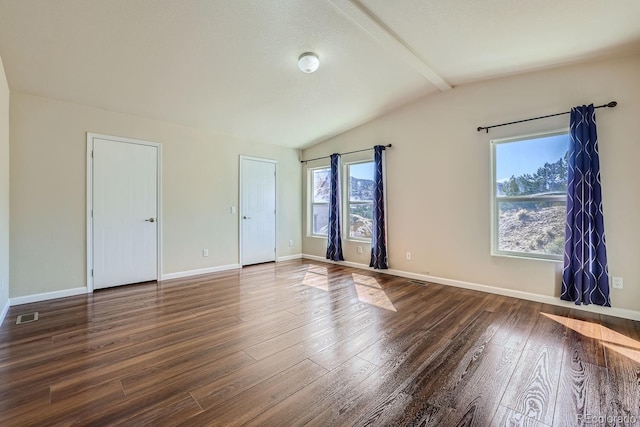 empty room featuring dark hardwood / wood-style floors and lofted ceiling with beams