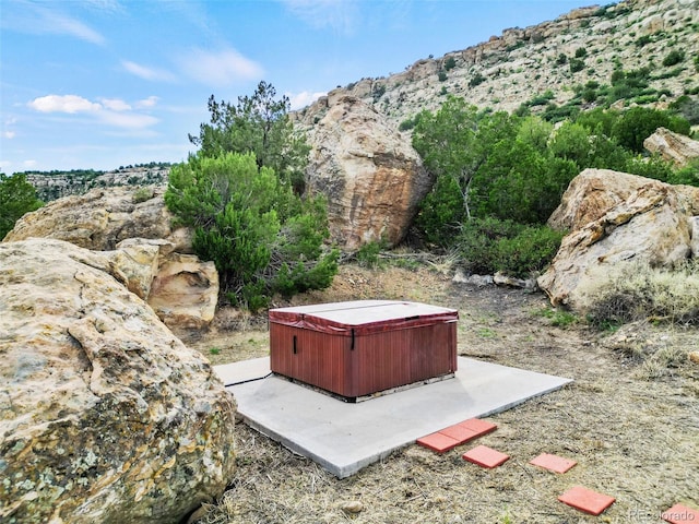 view of yard with a mountain view and a hot tub