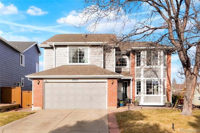 traditional home with brick siding, concrete driveway, roof with shingles, and a front yard