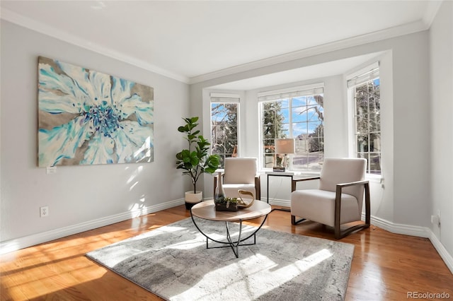 sitting room with baseboards, wood finished floors, and ornamental molding