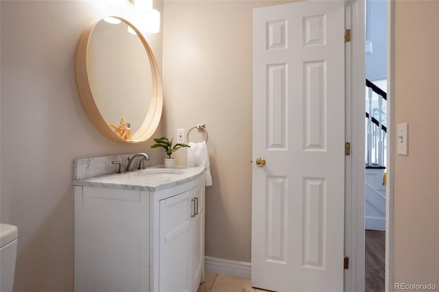 bathroom featuring vanity, toilet, and baseboards