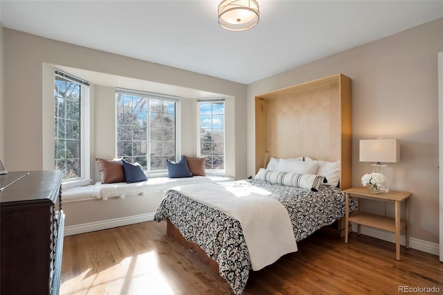 bedroom with baseboards and wood finished floors