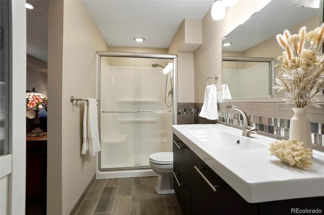 full bath featuring toilet, a stall shower, vanity, and wood tiled floor