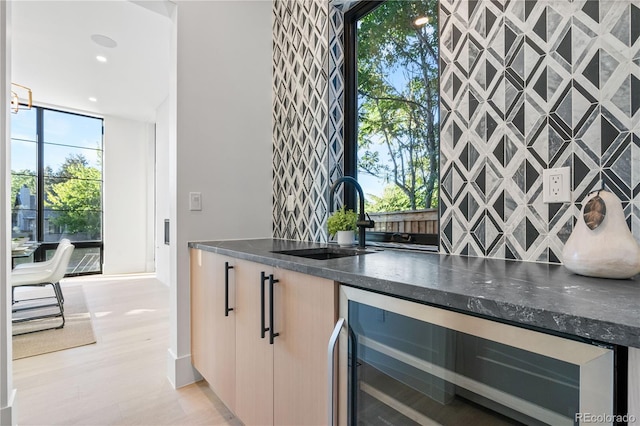 bar featuring tile walls, dark stone countertops, sink, and wine cooler