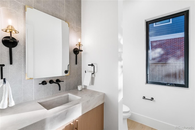 bathroom featuring vanity, tile walls, toilet, and hardwood / wood-style flooring