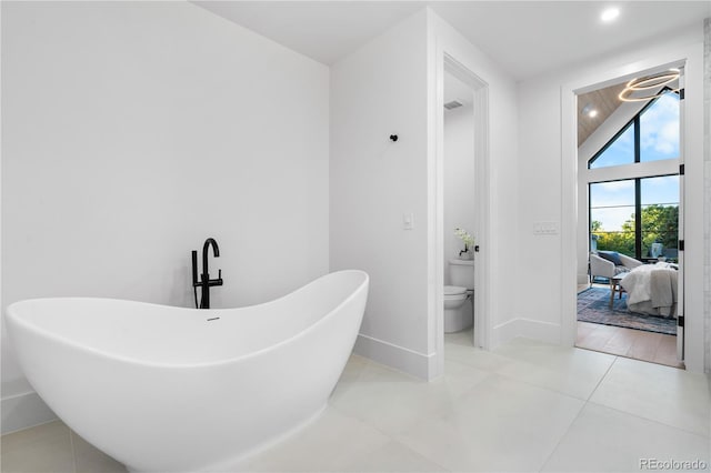 bathroom with tile patterned floors, a bathtub, and toilet