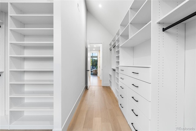 walk in closet with lofted ceiling and light hardwood / wood-style floors