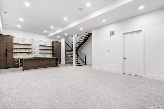 basement featuring light carpet and sink