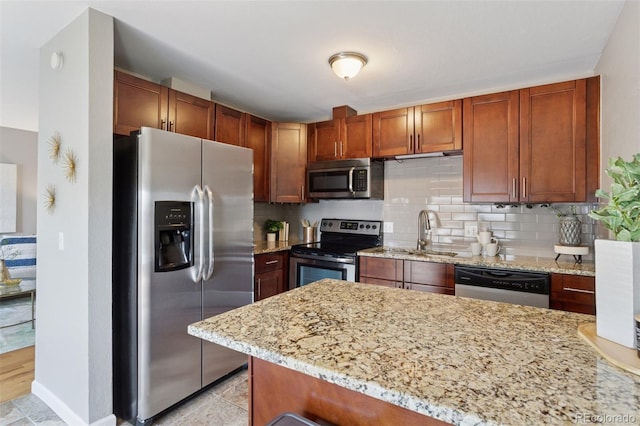 2854 N Lowell Blvd, Denver, CO 80211 - kitchen featuring stainless steel appliances, a peninsula, light stone counters, and decorative backsplash