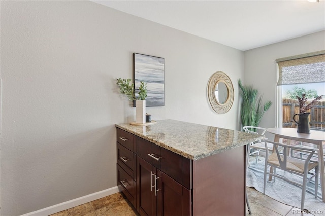 2854 N Lowell Blvd, Denver, CO 80211 - kitchen featuring light stone countertops, a peninsula, and dark brown cabinets