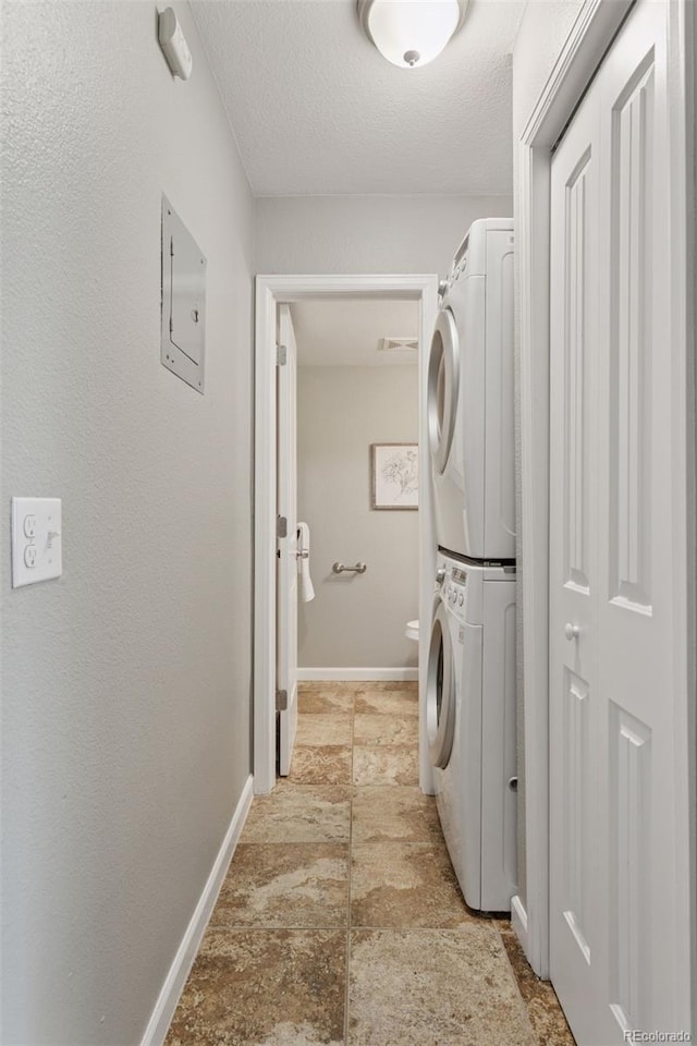 2854 N Lowell Blvd, Denver, CO 80211 - laundry area with stacked washer and clothes dryer, a textured ceiling, and light stone finish flooring