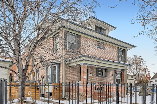 traditional style home featuring brick siding and a fenced front yard