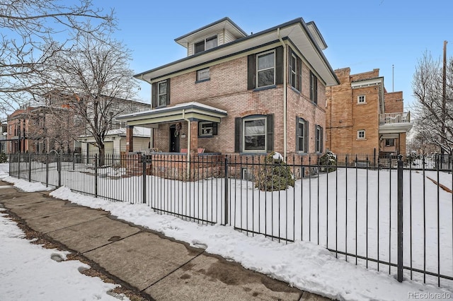 american foursquare style home with a fenced front yard and brick siding