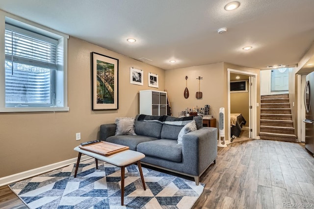 living area with stairway, recessed lighting, wood finished floors, and baseboards