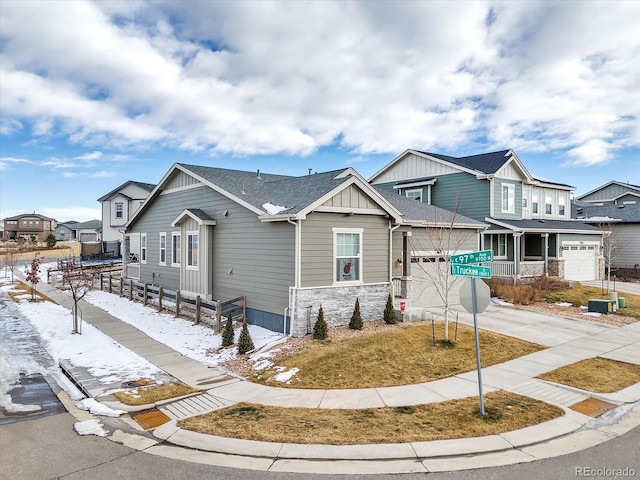 view of front of property with a shingled roof, board and batten siding, a garage, a residential view, and driveway