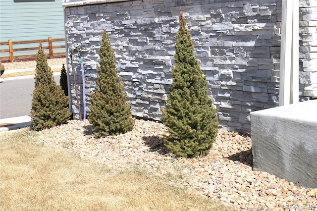 exterior details with stone siding and fence