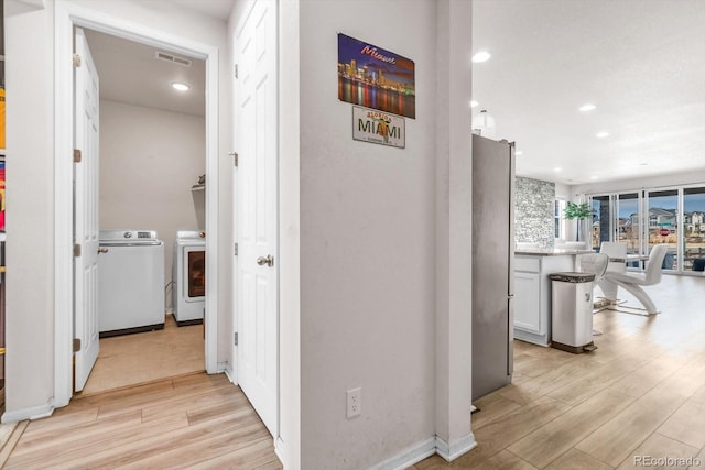 hallway with recessed lighting, visible vents, independent washer and dryer, and light wood-style flooring