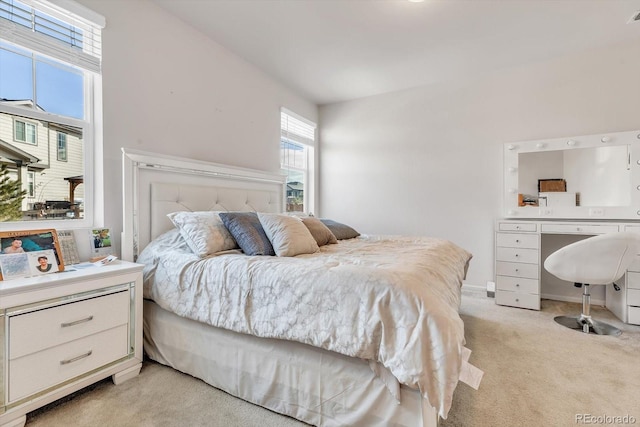 bedroom with light colored carpet and baseboards