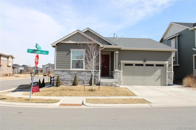 craftsman inspired home featuring a garage, stone siding, board and batten siding, and concrete driveway