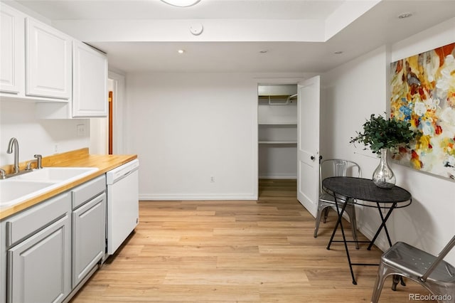 1120 N Clarkson St Unit 6, Denver, CO 80218 - kitchen with white dishwasher, a sink, light wood-style floors, white cabinets, and light countertops