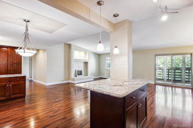 kitchen featuring pendant lighting, light stone counters, and dark wood-type flooring