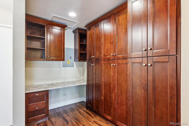 kitchen featuring built in desk, light stone counters, and dark hardwood / wood-style flooring